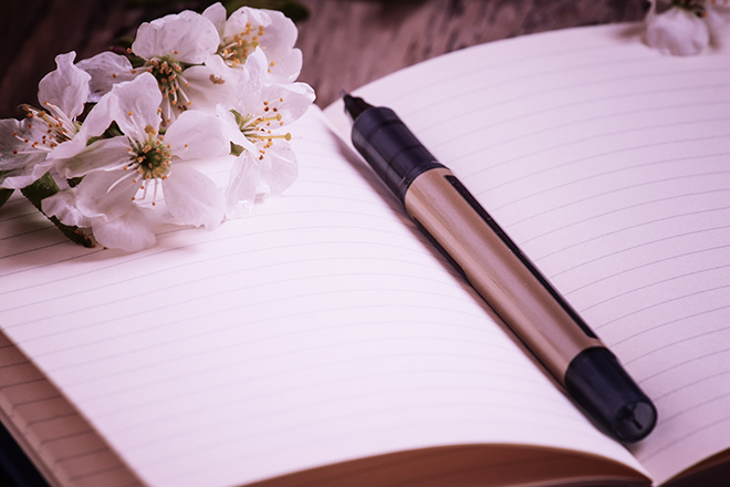 cherry blossom on a notepad with a pen, selective focus