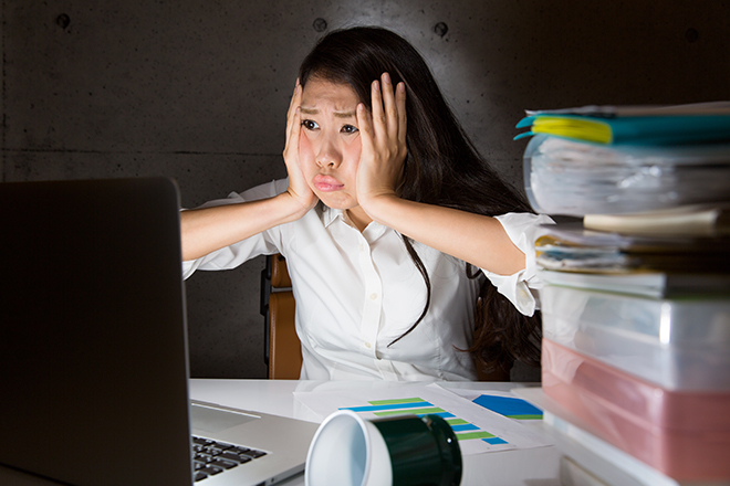会社で頭を抱える女性