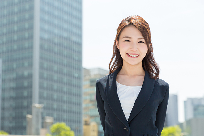 スーツ姿でほほ笑む女性