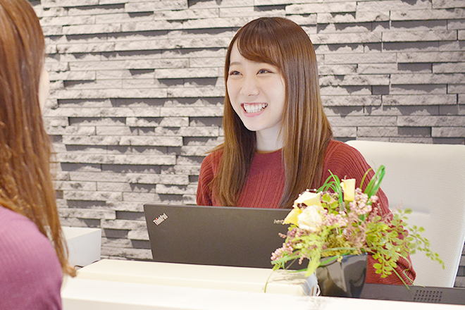 笑顔で来客対応する美人事