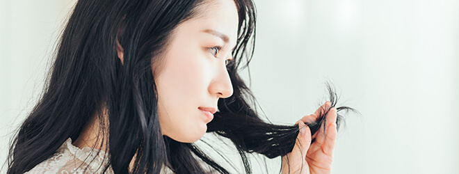 髪の先をいじる女性